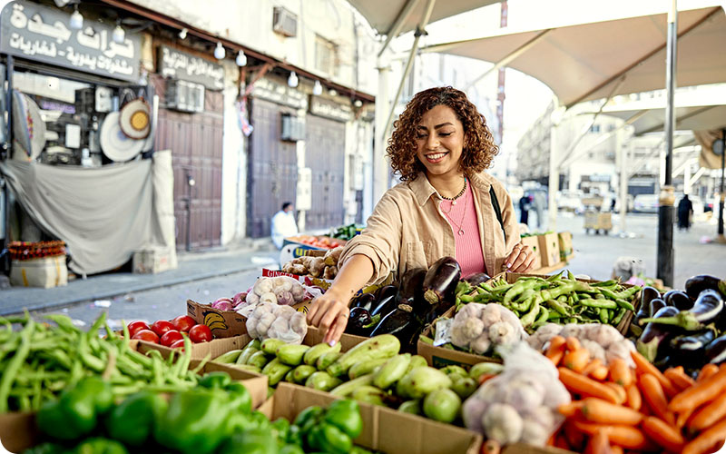A girl choosing vegetables at an outdoor market